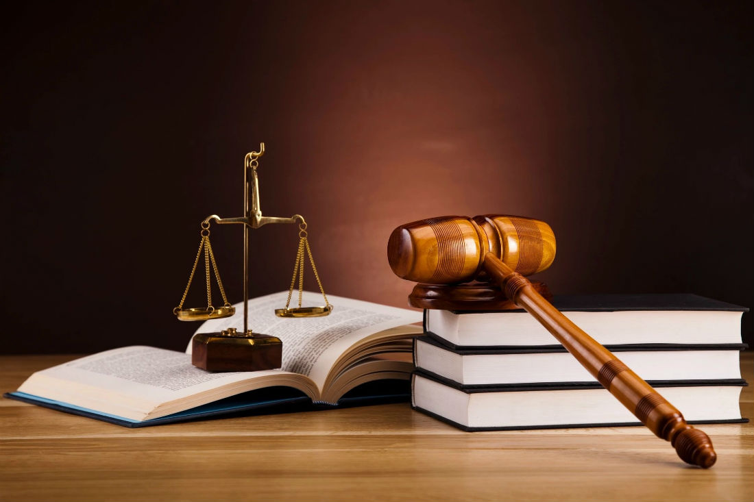 A judge 's gavel and scale on top of books.